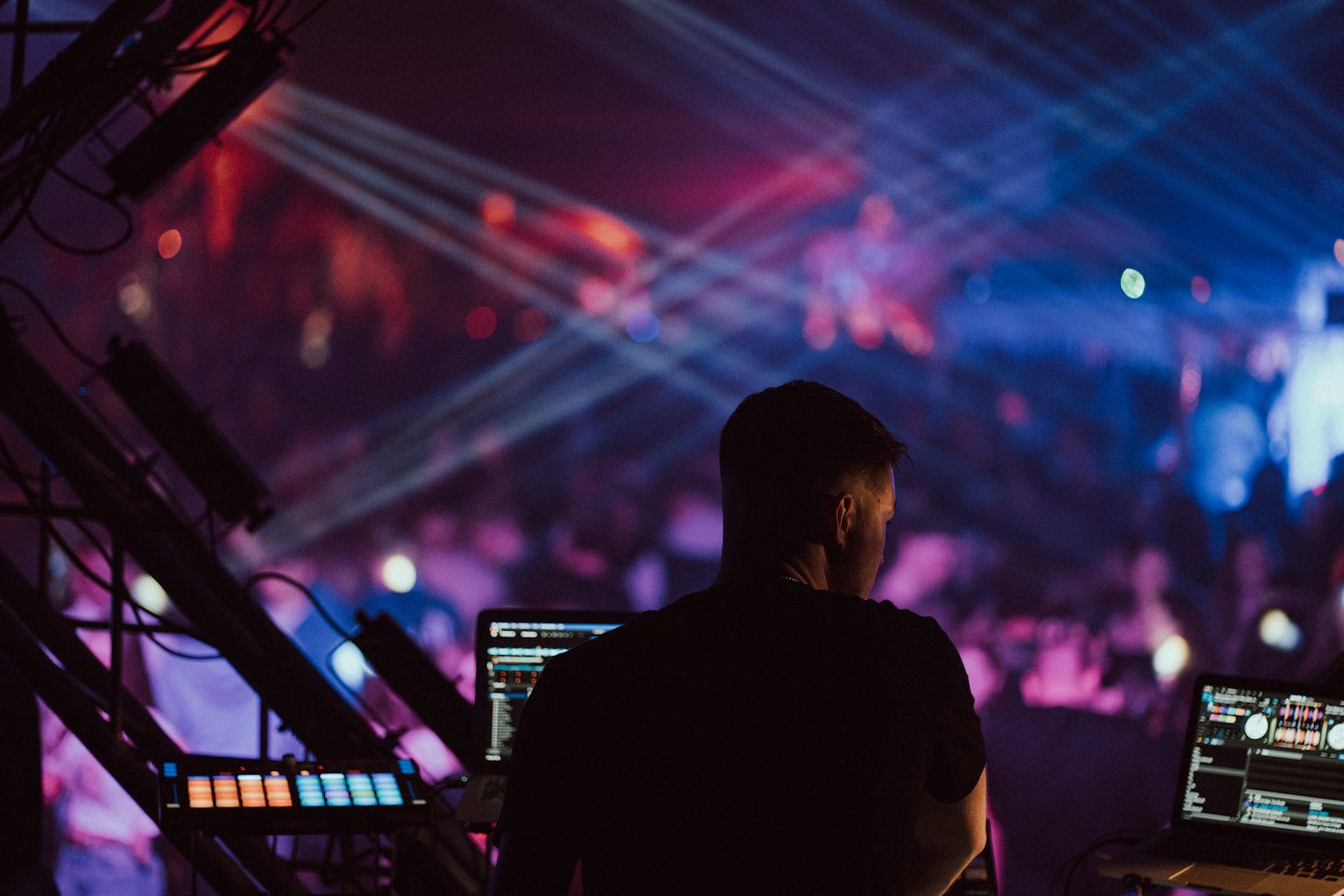 DJ aux commandes d'une table de mixage sur scène pendant une prestation.